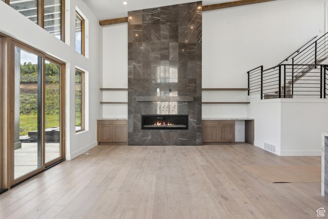 5758 Cobalt Cir Unit 12, Park City, UT 84098 - unfurnished living room featuring a high ceiling, plenty of natural light, baseboards, wood finished floors, and a tiled fireplace