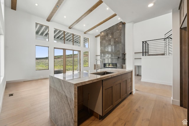 5758 Cobalt Cir Unit 12, Park City, UT 84098 - kitchen featuring a sink, a center island with sink, open floor plan, a large fireplace, and beamed ceiling