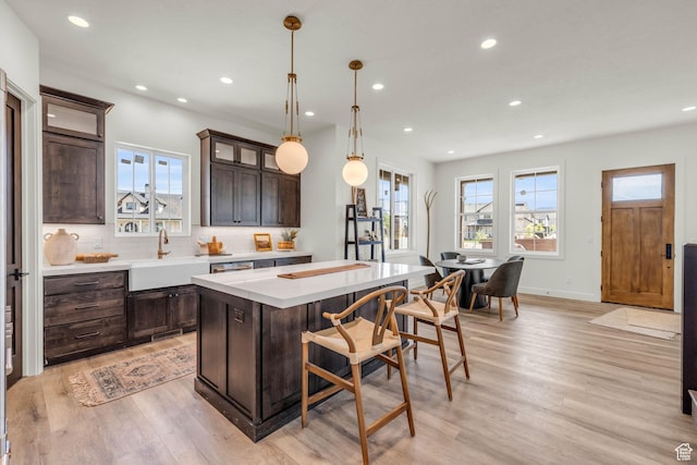 1333 Sage Way Unit 45, Francis, UT 84036 - kitchen with dark brown cabinets, sink, pendant lighting, a center island, and light hardwood / wood-style floors