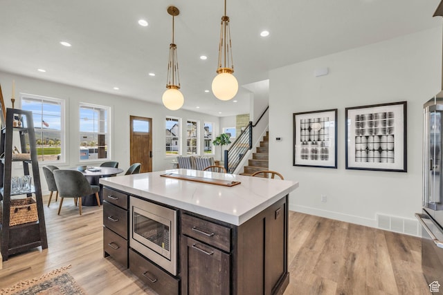 1333 Sage Way Unit 45, Francis, UT 84036 - kitchen with a wealth of natural light, stainless steel microwave, light hardwood / wood-style floors, and decorative light fixtures