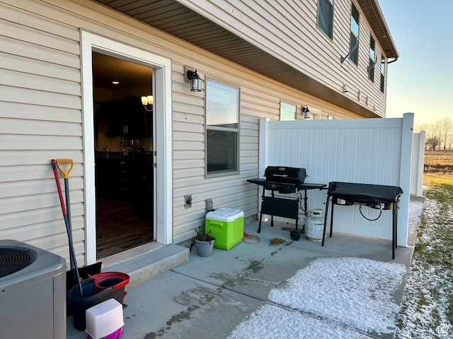 patio terrace at dusk featuring central AC unit and area for grilling