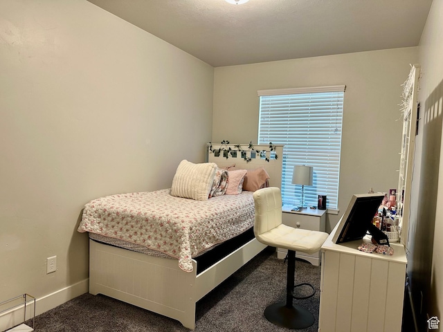 bedroom with multiple windows and dark colored carpet