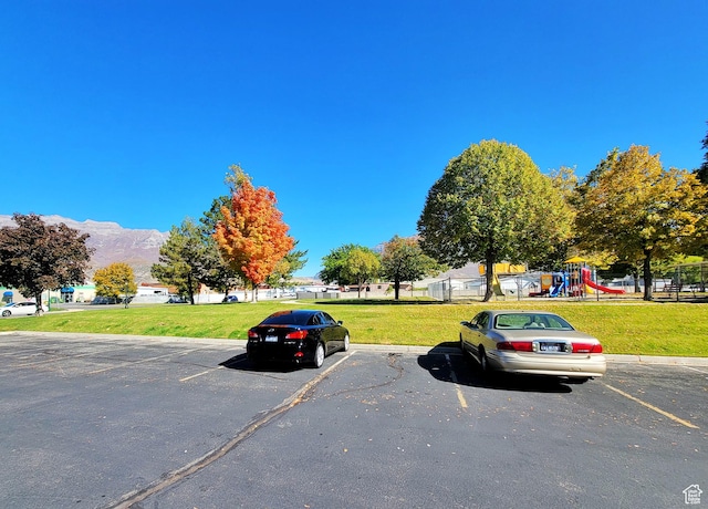 uncovered parking lot featuring a mountain view and playground community