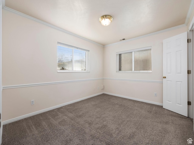 unfurnished room with crown molding, visible vents, baseboards, and carpet