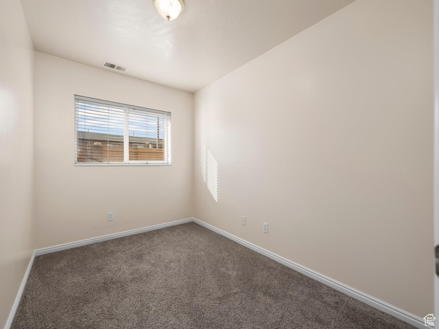 carpeted empty room featuring visible vents and baseboards