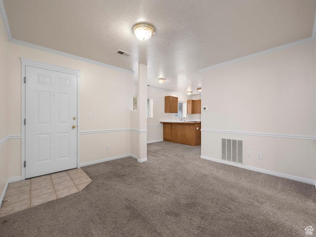 unfurnished living room featuring light carpet, visible vents, and crown molding