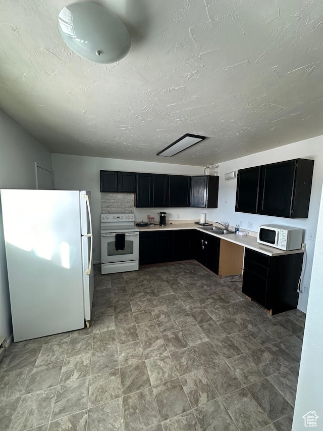 555 N 9th St, Montpelier, ID 83254 - kitchen featuring white appliances, dark cabinets, light countertops, a textured ceiling, and a sink