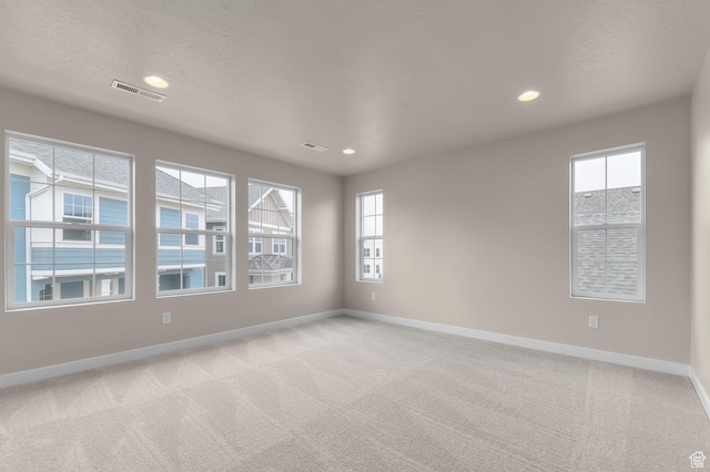 spare room with recessed lighting, visible vents, baseboards, and light colored carpet