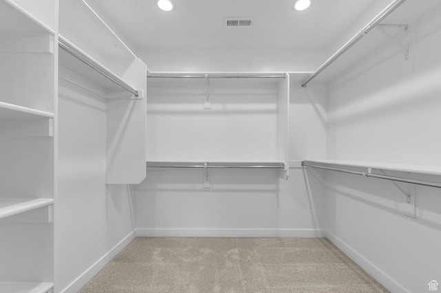 walk in closet with visible vents and light carpet