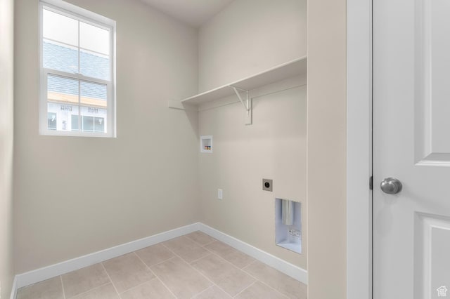 clothes washing area with electric dryer hookup, light tile patterned flooring, baseboards, hookup for a washing machine, and laundry area