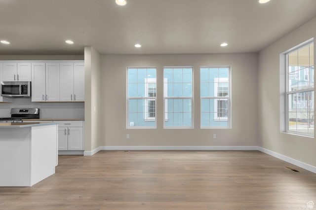 kitchen featuring stainless steel appliances, visible vents, light wood-style flooring, and white cabinetry