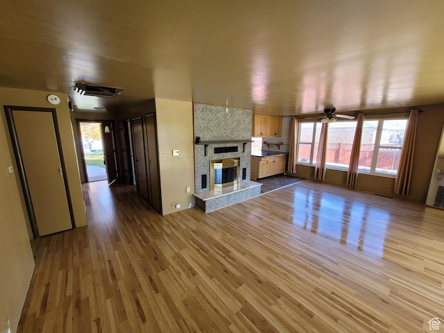 unfurnished living room with a wealth of natural light, light hardwood / wood-style flooring, and ceiling fan