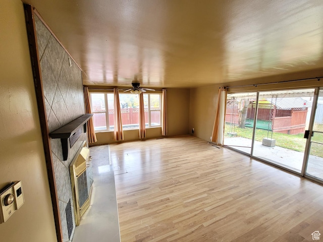 636 E 300 N, American Fork, UT 84003 - unfurnished living room with light wood-type flooring, a ceiling fan, heating unit, and a large fireplace