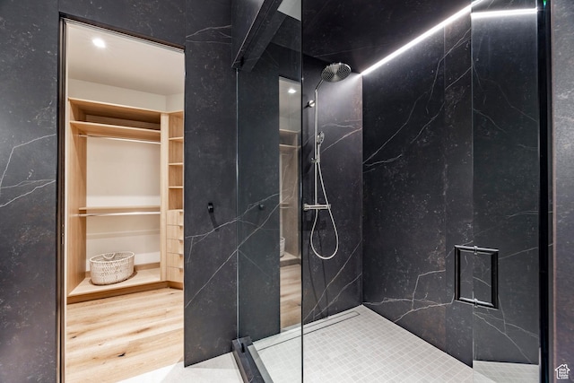 full bathroom with wood finished floors and a marble finish shower