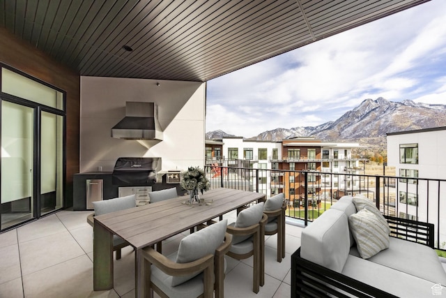 balcony featuring a grill, a mountain view, outdoor dining area, and an outdoor hangout area
