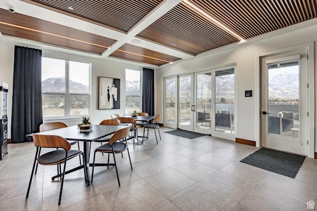 dining area featuring a mountain view, baseboards, beam ceiling, french doors, and coffered ceiling
