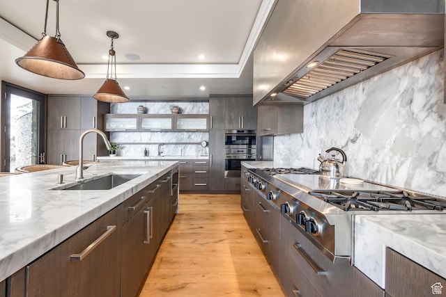 2848 W Deer Pointe Dr, Park City, UT 84060 - kitchen featuring wall chimney range hood, a sink, decorative backsplash, double oven, and light wood-type flooring
