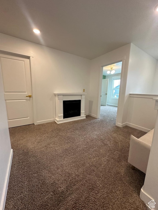 unfurnished living room with dark colored carpet