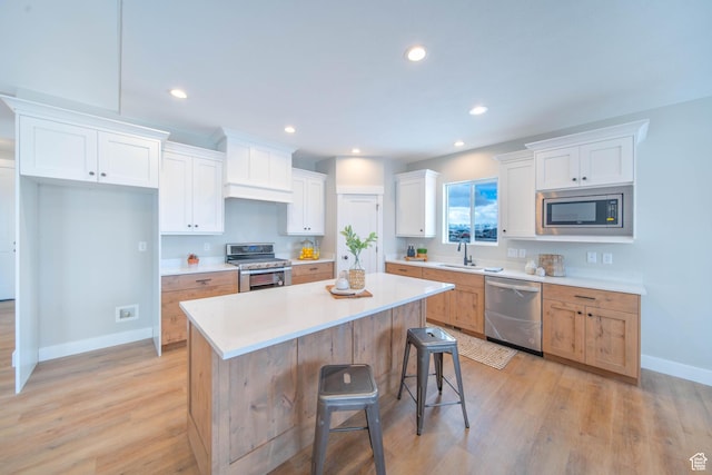 1436 E Parker Ln Unit 426, Lake Point, UT 84074 - kitchen with stainless steel appliances, a sink, light wood-type flooring, baseboards, and white cabinetry