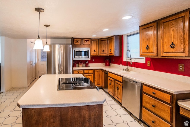 kitchen with sink, hanging light fixtures, stainless steel appliances, and a kitchen island