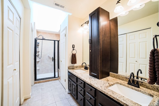 bathroom with tile patterned floors, a shower with door, and vanity