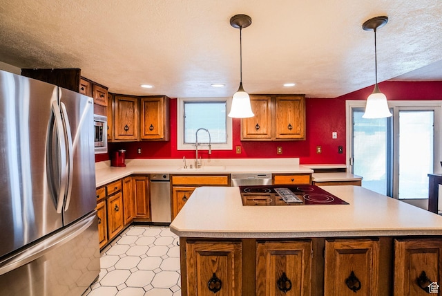 kitchen with sink, stainless steel appliances, a center island, and pendant lighting