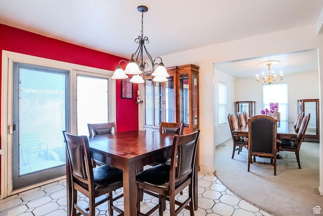 dining space featuring carpet floors, ornamental molding, and a notable chandelier