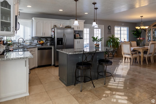 1158 E 650 N, Ogden, UT 84404 - kitchen with appliances with stainless steel finishes, a sink, white cabinets, a kitchen bar, and recessed lighting