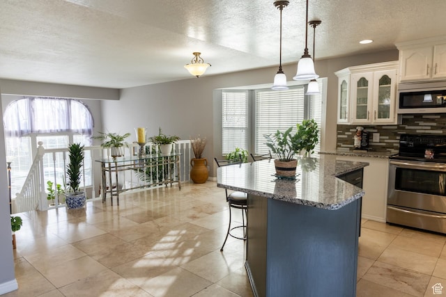 1158 E 650 N, Ogden, UT 84404 - kitchen with stainless steel appliances, plenty of natural light, backsplash, white cabinets, and a textured ceiling