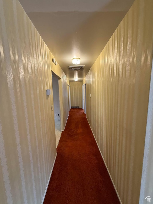 corridor featuring dark carpet and visible vents