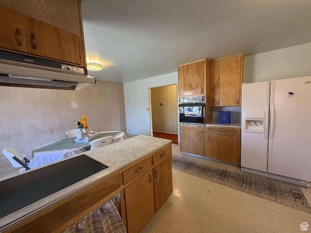 kitchen with light countertops, oven, white fridge with ice dispenser, brown cabinetry, and light floors