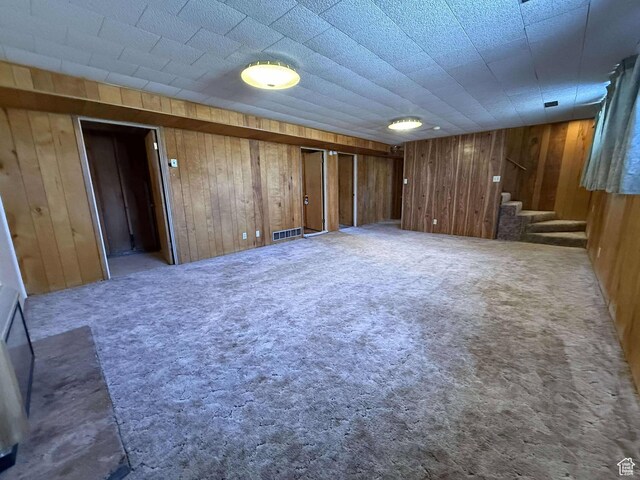 885 N 600 E, Price, UT 84501 - unfurnished living room featuring stairs, wooden walls, and carpet flooring