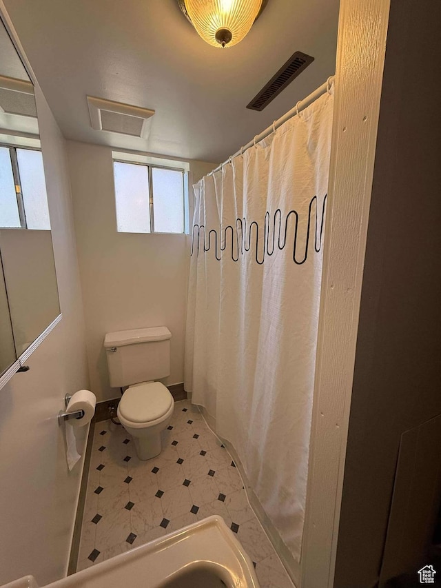 full bathroom with visible vents, toilet, and a shower with shower curtain