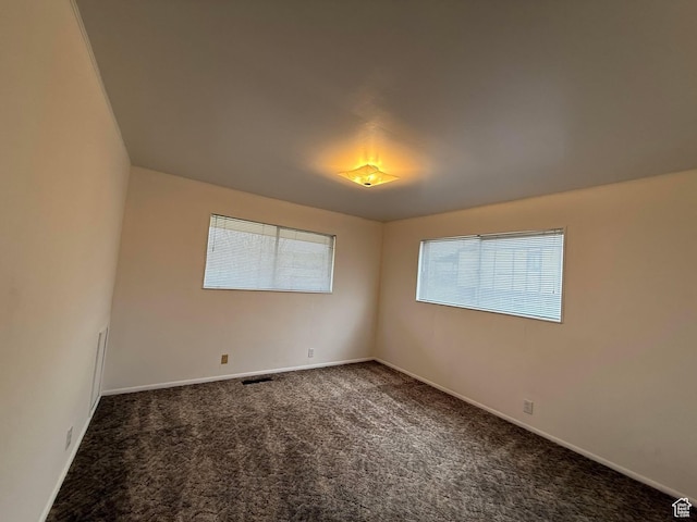 carpeted spare room with baseboards and visible vents