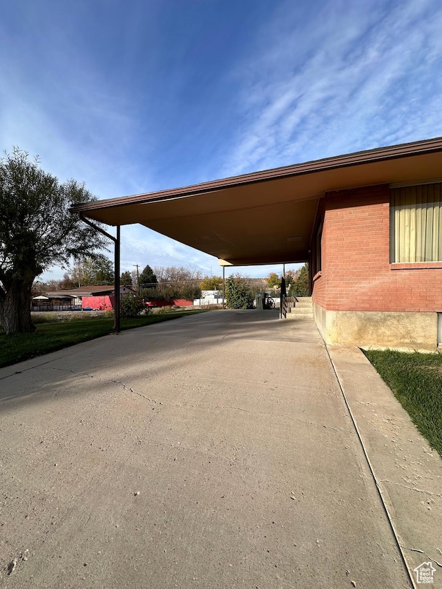 view of parking with an attached carport and driveway