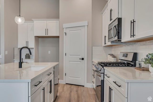3527 W Haven Aire, South Jordan, UT 84095 - kitchen with tasteful backsplash, stainless steel appliances, light wood-style floors, a sink, and white cabinetry