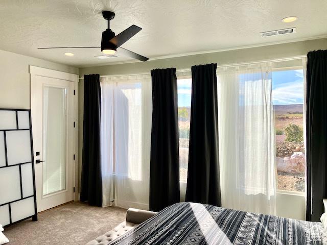 3260 Retreat Dr S, Hurricane, UT 84737 - carpeted bedroom featuring a textured ceiling, multiple windows, and ceiling fan