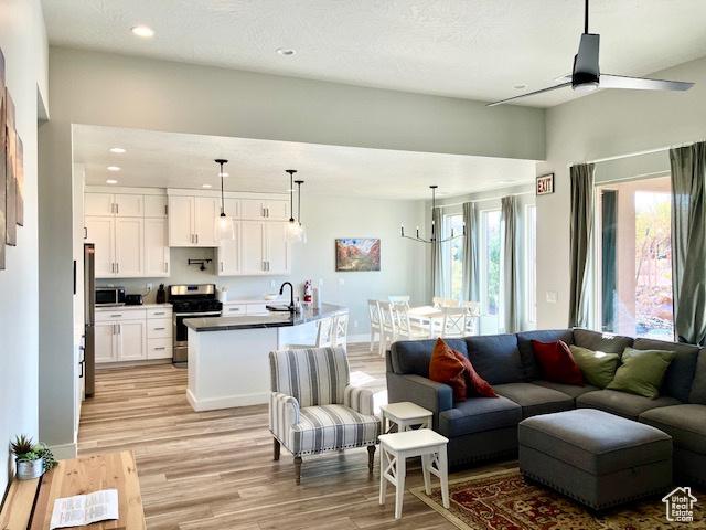 3260 Retreat Dr S, Hurricane, UT 84737 - living room with a textured ceiling, ceiling fan with notable chandelier, sink, and light hardwood / wood-style flooring
