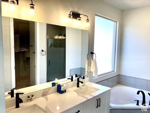 3260 Retreat Dr S, Hurricane, UT 84737 - bathroom featuring tiled tub and vanity