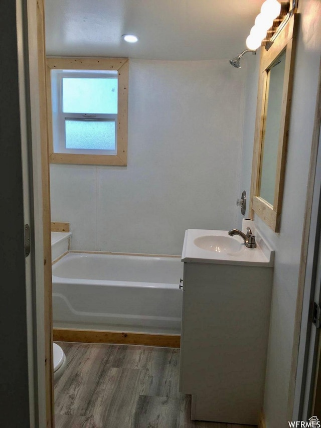 250 W 700 S, Richfield, UT 84701 - bathroom featuring hardwood / wood-style flooring, toilet, a washtub, and vanity