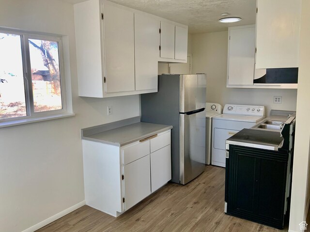 250 W 700 S, Richfield, UT 84701 - kitchen featuring washer / clothes dryer, white cabinets, and light hardwood / wood-style floors