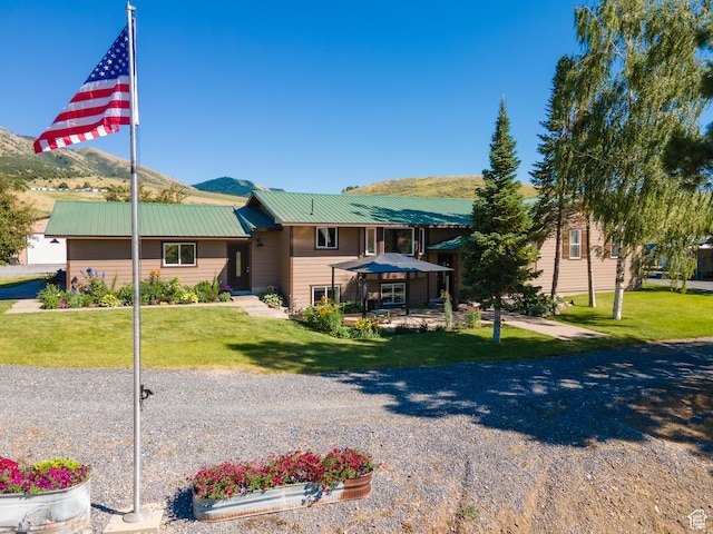 view of front of home featuring a mountain view and a front lawn