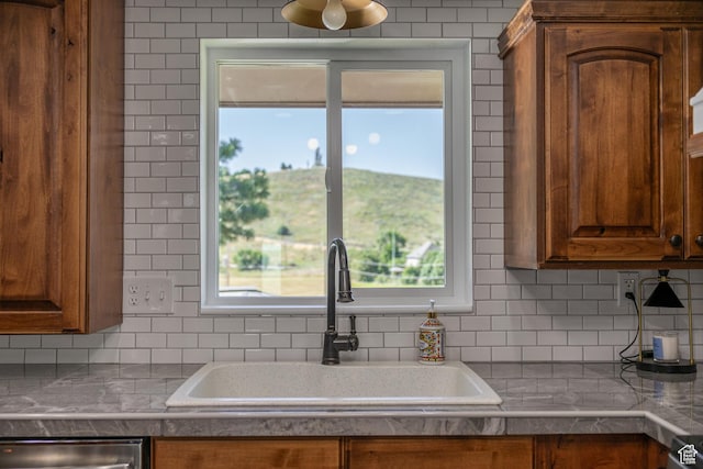 kitchen featuring backsplash, a healthy amount of sunlight, and sink