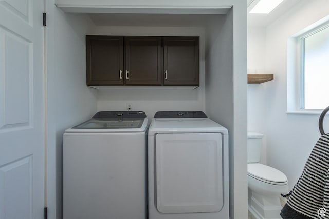 washroom with cabinets and washer and clothes dryer