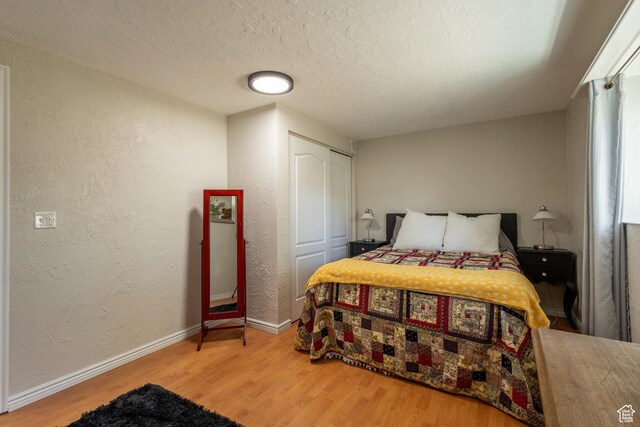 bedroom featuring a closet, a textured ceiling, and hardwood / wood-style flooring