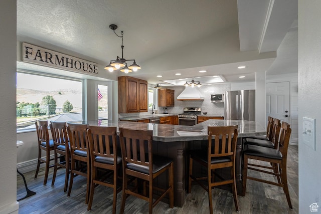 dining room with a textured ceiling, vaulted ceiling, dark wood-type flooring, and sink