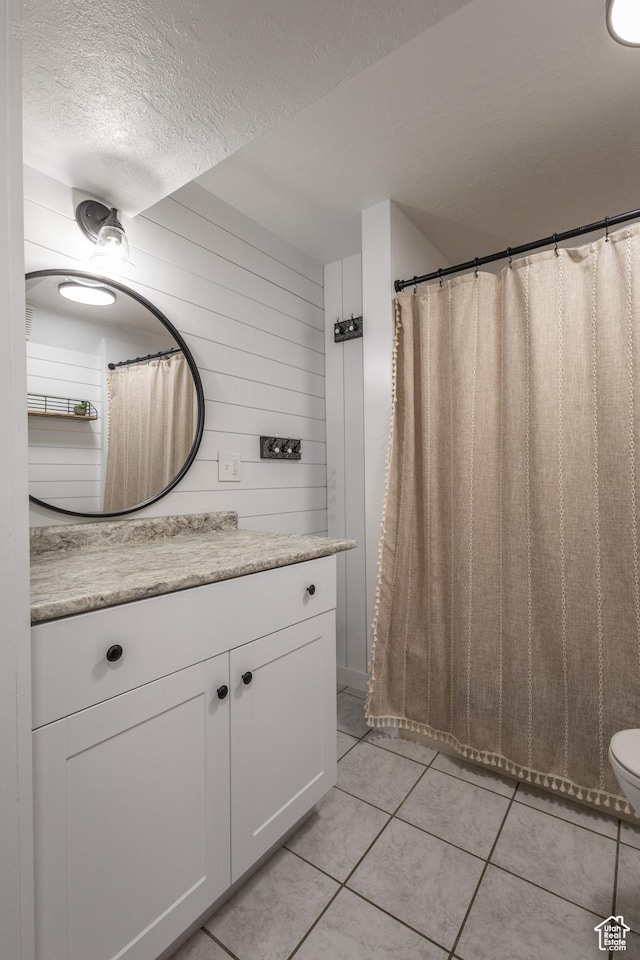 bathroom featuring tile patterned flooring, vanity, and a textured ceiling