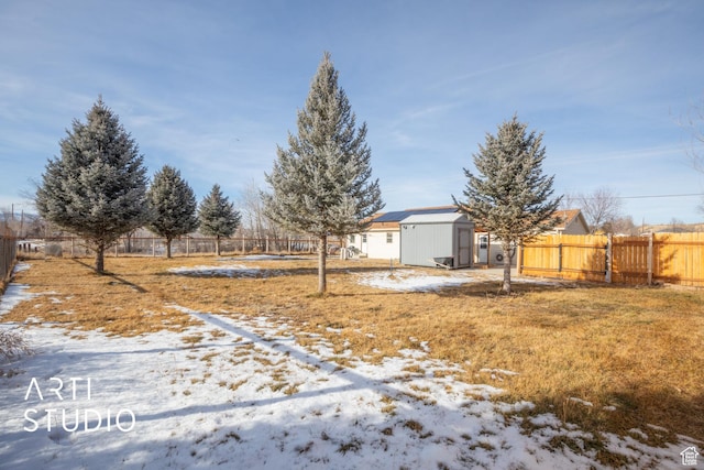 yard layered in snow featuring a storage shed