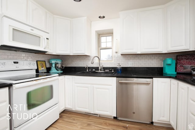 kitchen featuring white cabinetry, sink, tasteful backsplash, light hardwood / wood-style flooring, and white appliances