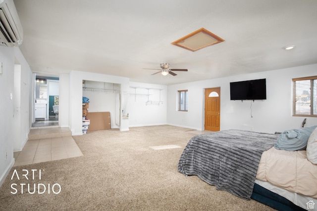 carpeted bedroom with a wall mounted AC and ceiling fan